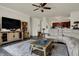 Open living space with hardwood floors, ceiling fan, and seamless flow to the kitchen area at 2307 Cedarmill Dr, Franklin, IN 46131