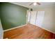 Bedroom boasts hardwood floors, complemented by contrasting green wall and a ceiling fan at 2317 St Peter St, Indianapolis, IN 46203