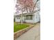 Quaint home featuring a blooming tree, tidy lawn, and a classic brick-lined driveway at 2317 St Peter St, Indianapolis, IN 46203