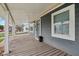 View of the covered porch with a gray exterior, white columns, and a gray door at 2336 St Paul St, Indianapolis, IN 46203