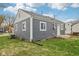 Rear view of gray home featuring new vinyl siding, white trim, new windows, and updated exterior features at 2336 St Paul St, Indianapolis, IN 46203