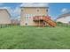 Backyard view showcases a large grassy area, perfect for recreation, leading up to a private wooden deck at 2889 Grimes Way, Columbus, IN 47201
