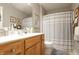 Bathroom featuring a wood vanity with modern fixtures, framed mirror, and shower with curtains at 2889 Grimes Way, Columbus, IN 47201