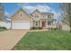 Charming two-story home with a well-manicured lawn and a cozy front porch with red door at 2889 Grimes Way, Columbus, IN 47201