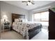 A well-lit main bedroom with a wooden bed frame, and a window with blinds at 2889 Grimes Way, Columbus, IN 47201