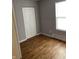 Bedroom with wood-look flooring, closet, window, and neutral gray paint at 2968 N Gale St, Indianapolis, IN 46218