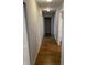 Hallway with laminate wood flooring and neutral paint leading to bedrooms and bathrooms at 2968 N Gale St, Indianapolis, IN 46218