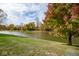 Scenic pond view with vibrant autumn trees reflecting in the calm water, set on a green lawn at 3241 W Keepsake Ln, Monrovia, IN 46157
