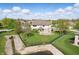 The aerial view highlights the backyard with green lawn, brick and siding exterior and patio at 3256 Waterside Ct, Greenwood, IN 46143