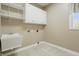 Functional laundry room with utility sink, storage cabinets, and tiled flooring at 3256 Waterside Ct, Greenwood, IN 46143