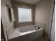 Bright bathroom featuring a soaking tub with tile surround and glass block window at 3806 Sycamore Bend S Way, Columbus, IN 47203