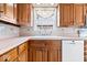 Bright kitchen featuring oak cabinets, a white dishwasher, tiled backsplash, and a large sink beneath the window at 4711 Cornelius Ave, Indianapolis, IN 46208