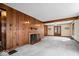 Stylish living room with wood paneled walls, a cozy fireplace, neutral carpet, and glass paneled doors, perfect for relaxing at 4711 Cornelius Ave, Indianapolis, IN 46208