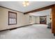 Spacious living room with neutral carpet, wood trim, fireplace, and large windows, perfect for relaxation and entertaining at 4711 Cornelius Ave, Indianapolis, IN 46208