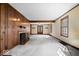 Bright living room with wood paneled walls, a cozy fireplace, neutral carpet, and glass paneled doors, perfect for gatherings at 4711 Cornelius Ave, Indianapolis, IN 46208