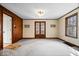 Bright living room with wood paneled walls, neutral carpet, and glass paneled doors, leading to an additional room at 4711 Cornelius Ave, Indianapolis, IN 46208