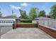 Spacious backyard featuring a brick retaining wall, detached garage and mature trees at 4720 Central Ave, Indianapolis, IN 46205