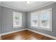 Comfortable bedroom featuring hardwood floors and two bright windows with natural light at 4720 Central Ave, Indianapolis, IN 46205