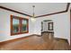 Sunlit dining area boasts hardwood flooring, wood trim, an elegant chandelier, and ample windows at 4720 Central Ave, Indianapolis, IN 46205