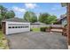 Detached two-car garage with a concrete driveway, surrounded by a fenced yard and mature trees at 4720 Central Ave, Indianapolis, IN 46205