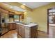 Updated kitchen features stainless appliances, island with cooktop, wood cabinets, and barstool seating at 4720 Central Ave, Indianapolis, IN 46205