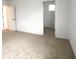 Neutral bedroom featuring a carpeted floor, with a door to another room with a window at 5115 Triple Crown Way, Indianapolis, IN 46237