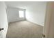 Bright, empty bedroom features neutral carpet, white walls, and a window at 5115 Triple Crown Way, Indianapolis, IN 46237
