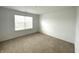 A simplistic bedroom offering neutral walls, carpet, and a window bringing in natural light at 5115 Triple Crown Way, Indianapolis, IN 46237