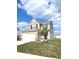 Attractive two-story home with a two-car garage, showcasing a manicured lawn and a young tree at 5115 Triple Crown Way, Indianapolis, IN 46237