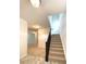 Bright hallway with carpeted stairs, neutral walls, and durable flooring at 5115 Triple Crown Way, Indianapolis, IN 46237