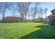 Large grassy backyard surrounded by mature trees, perfect for outdoor activities at 5202 Logan Ln, Indianapolis, IN 46250