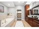 Luxurious bathroom features a soaking tub, double vanity with granite countertop, and a tiled walk-in shower at 5202 Logan Ln, Indianapolis, IN 46250