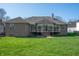 Back exterior view of a brick home with a sunroom and a well-maintained lawn at 5202 Logan Ln, Indianapolis, IN 46250