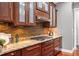 Kitchen featuring wooden cabinets, granite countertops, stainless steel appliances, and decorative backsplash at 5202 Logan Ln, Indianapolis, IN 46250