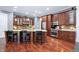 The kitchen boasts dark wood cabinets, stainless steel appliances, and a granite-topped center island with seating at 5202 Logan Ln, Indianapolis, IN 46250