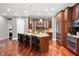 Open kitchen featuring dark wood cabinets, stainless steel appliances, granite countertops and a center island with seating at 5202 Logan Ln, Indianapolis, IN 46250