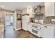 Well-lit kitchen featuring white cabinets, a stainless steel range hood, and a mosaic backsplash at 524 N Meridian St, Lebanon, IN 46052