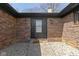 Covered brick entryway with black front door, modern sconces, and manicured gravel landscaping at 5344 Tincher Rd, Indianapolis, IN 46221