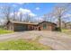 Brick home featuring attached garage, large driveway, beautiful architectural details, and mature trees at 5344 Tincher Rd, Indianapolis, IN 46221