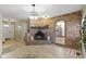 Cozy living room featuring a brick fireplace, chandelier, and wood-look floors at 5344 Tincher Rd, Indianapolis, IN 46221