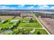 Wide aerial shot showcasing the property's pond, outbuildings, and expansive green spaces under a partly cloudy sky at 5442 W 400 N, Fairland, IN 46126