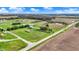 Expansive aerial view of property with lush green fields, mature trees, and outbuildings under a bright blue sky at 5442 W 400 N, Fairland, IN 46126