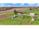 Overhead view of property featuring multiple outbuildings, mature trees, and spacious green fields under a bright sky at 5442 W 400 N, Fairland, IN 46126