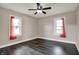 A spacious bedroom with dark floors and two windows offering ample natural light and ceiling fan at 5442 W 400 N, Fairland, IN 46126
