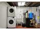 Functional basement laundry room, including stacked washer/dryer, utility sink, and modern water system at 5442 W 400 N, Fairland, IN 46126