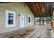 Covered porch showing wood flooring and ceiling, plus natural light, with a view of the surrounding greenery at 5442 W 400 N, Fairland, IN 46126