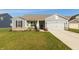 Charming single-Gathering home showcasing a well-manicured lawn and a gray siding exterior with an attached garage at 5694 Walkabout Way, Brownsburg, IN 46112