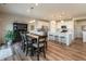 Open concept living space with wood floors, dining table, and kitchen island at 5694 Walkabout Way, Brownsburg, IN 46112
