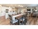 Open concept living space with wood floors, kitchen island, dining area, and living room at 5694 Walkabout Way, Brownsburg, IN 46112