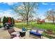 Backyard patio with cushioned seating, a grill, and string lights offers a cozy and inviting outdoor space at 594 N Shore Blvd, Franklin, IN 46131